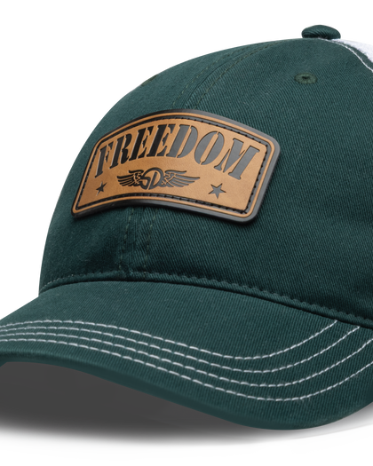 Freedom Hat in Green, close-up front view featuring a tan leather patch reading "Freedom" with the Straight Down logo and star accents, white contrast stitching detail on the green structured brim