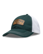 Freedom Hat in Green, side view featuring a forest green and white mesh trucker hat with a leather "Freedom" and Straight Down logo patch on the front panel with white contrast stitching