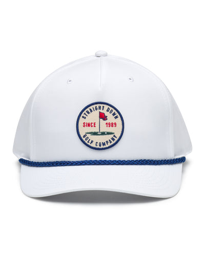 Pin High Rope Hat in White, front view featuring a Straight Down Golf Company circular patch depicting a golf hole with a red flag and "Since 1989" text, on a white hat with a blue rope brim detail