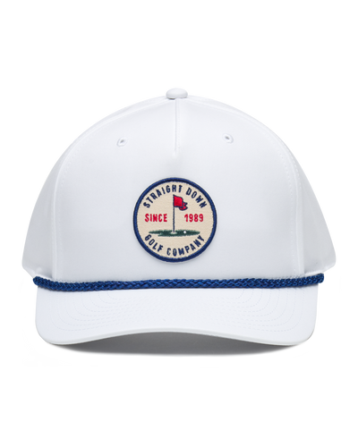 Pin High Rope Hat in White, front view featuring a Straight Down Golf Company circular patch depicting a golf hole with a red flag and "Since 1989" text, on a white hat with a blue rope brim detail