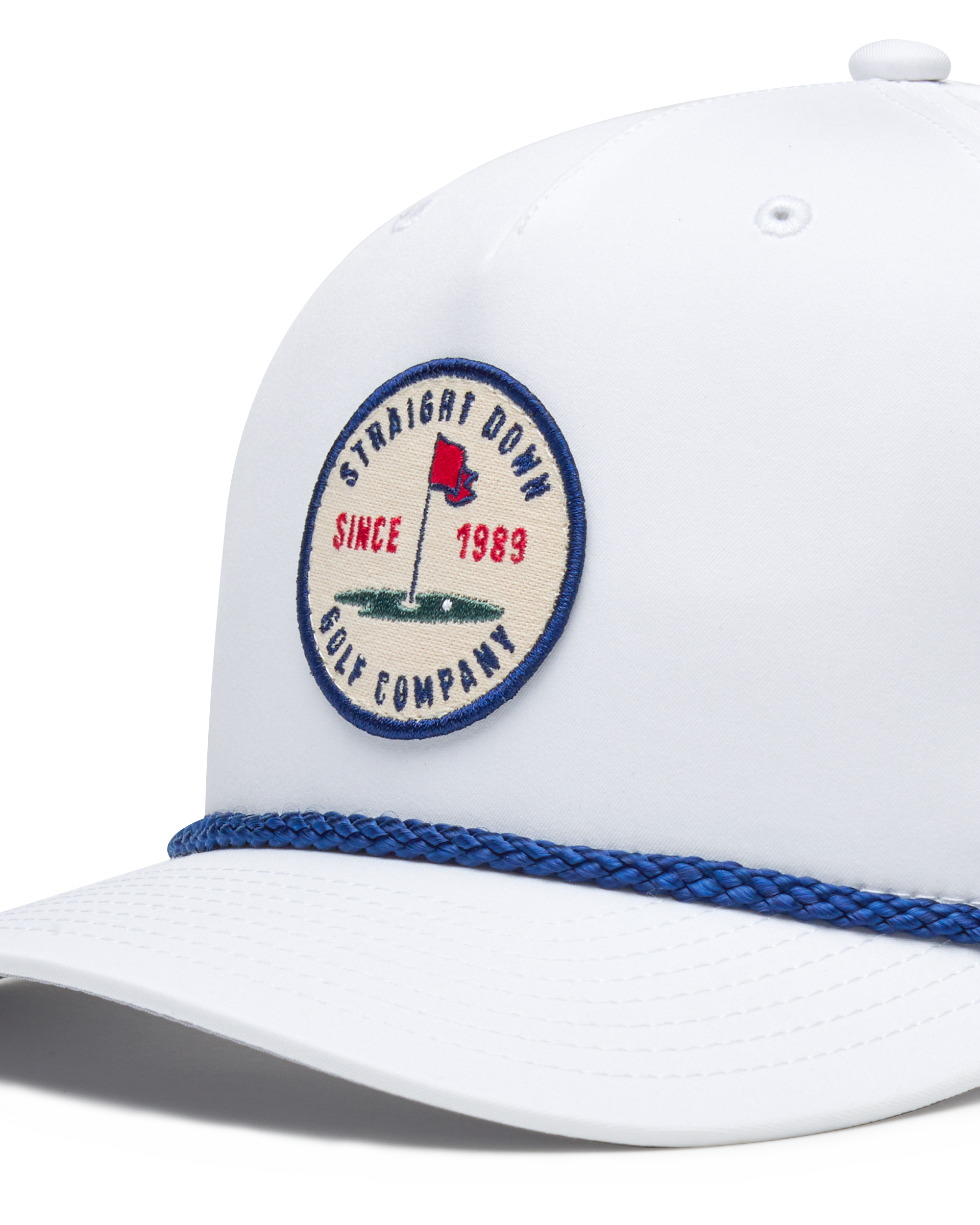 Pin High Rope Hat in White, close-up detail of the Straight Down Golf Company circular patch depicting a golf hole with a red flag and 