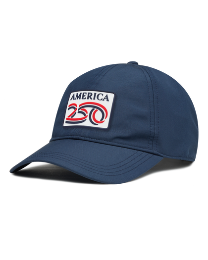 A navy structured baseball cap with a curved brim, featuring a front patch that reads 'AMERICA 250' in navy, red, and white. The cap has perforated side panels for ventilation.