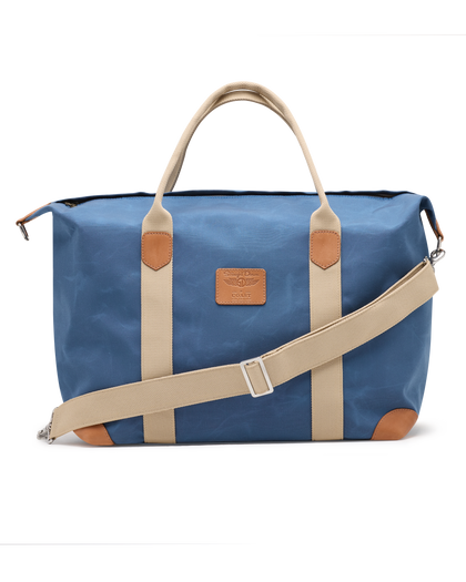 Weekender Bag in Moonlight, front product view featuring a blue waxed canvas body with tan canvas handles, tan leather trim accents, adjustable shoulder strap, and Straight Down logo patch