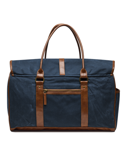 Back view of the Waxed Canvas Duffle Bag in Navy, highlighting the brown leather handles, exterior zippered pocket, and leather trim.