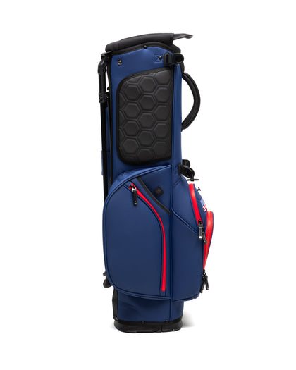 Straight Down Lux Carry Stand Bag in Navy Red, side profile view featuring black hexagon-embossed padded pocket, red zipper trim, rounded lower pockets, and dual carry handle