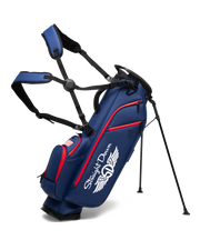 Straight Down Lux Carry Stand Bag in Navy Red, front angle view featuring white Straight Down wing logo, red zipper accents, American flag patch, dual shoulder straps, and deployed kickstand legs