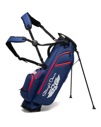 Straight Down Lux Carry Stand Bag in Navy Red, front angle view featuring white Straight Down wing logo, red zipper accents, American flag patch, dual shoulder straps, and deployed kickstand legs