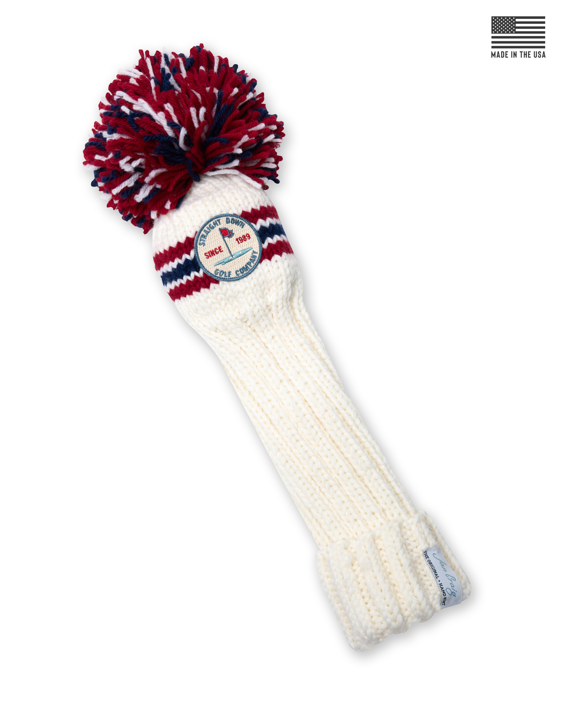 Straight Down Pom Pom Driver Headcover in Red White Blue, product view featuring a cream hand-knit cable knit driver headcover with red and navy stripe detail, an oversized red, white, and navy pom pom, and the Straight Down Golf Company Since 1989 patch