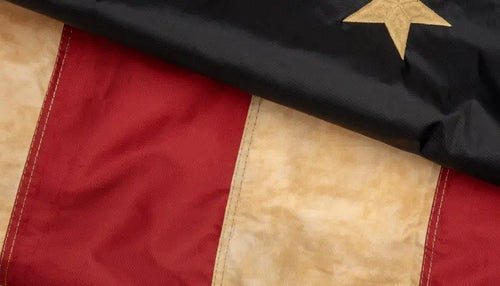 Vintage American flag with weathered stars and stripes in red, white, and blue.