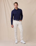 Model wearing the Cambridge Long Sleeve Polo in New Indigo paired with light-colored golf pants