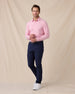 Model wearing the Cambridge Long Sleeve Polo in Punch Pink paired with navy golf pants