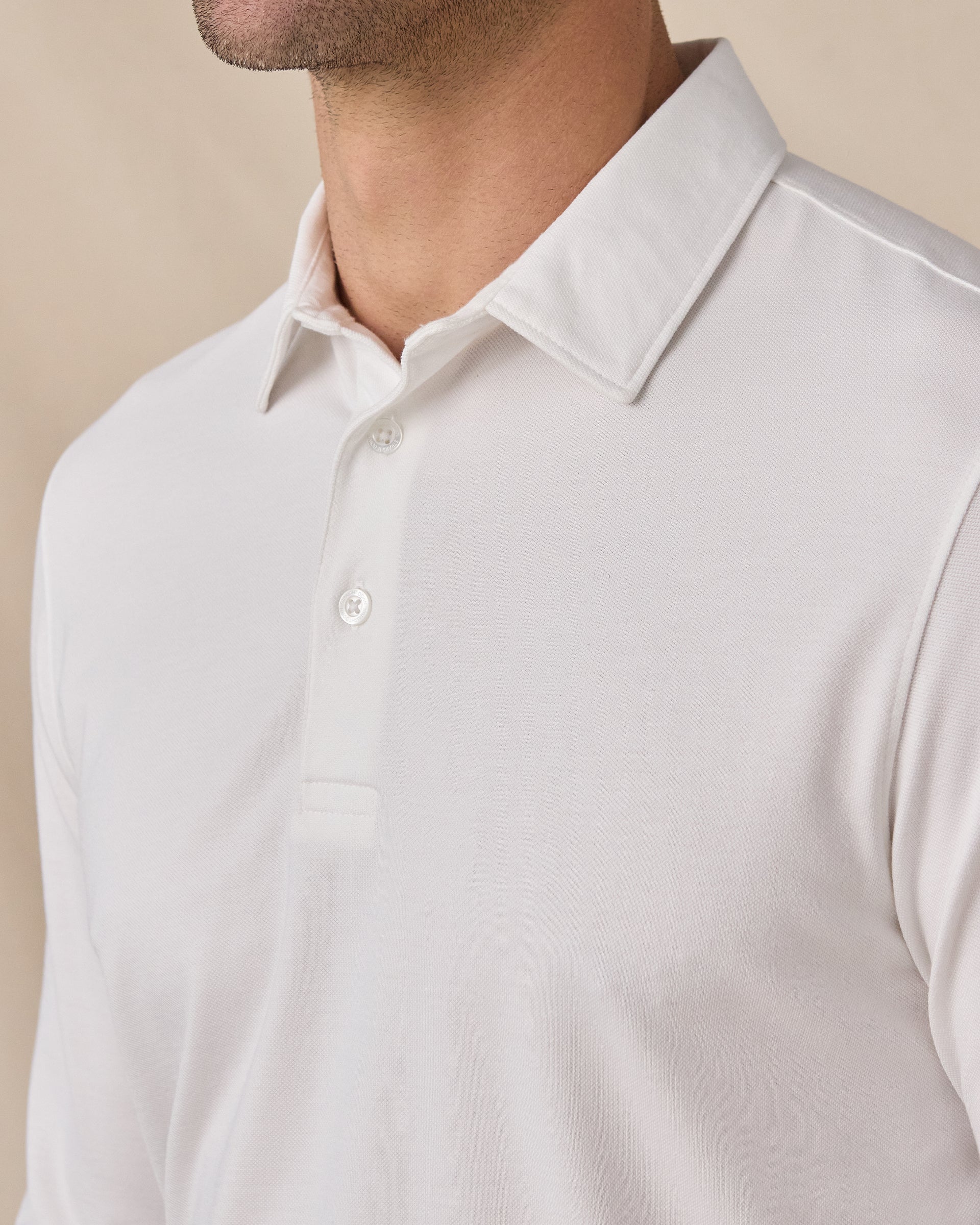Close-up of the Cambridge Long Sleeve Polo in White featuring the structured collar, oxford pique knit texture, and button placket