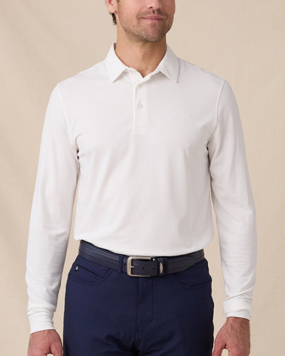 Model wearing the Cambridge Long Sleeve Polo in White, styled with navy golf pants