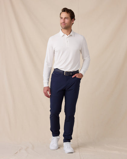 Model wearing the Cambridge Long Sleeve Polo in White paired with navy golf pants