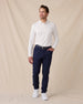 Model wearing the Cambridge Long Sleeve Polo in White paired with navy golf pants