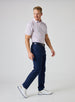 Grillin' Polo in White, full body on model side view featuring a white base with an all-over scattered print in red and blue tones, styled with navy pants, a navy belt, and white golf shoes
