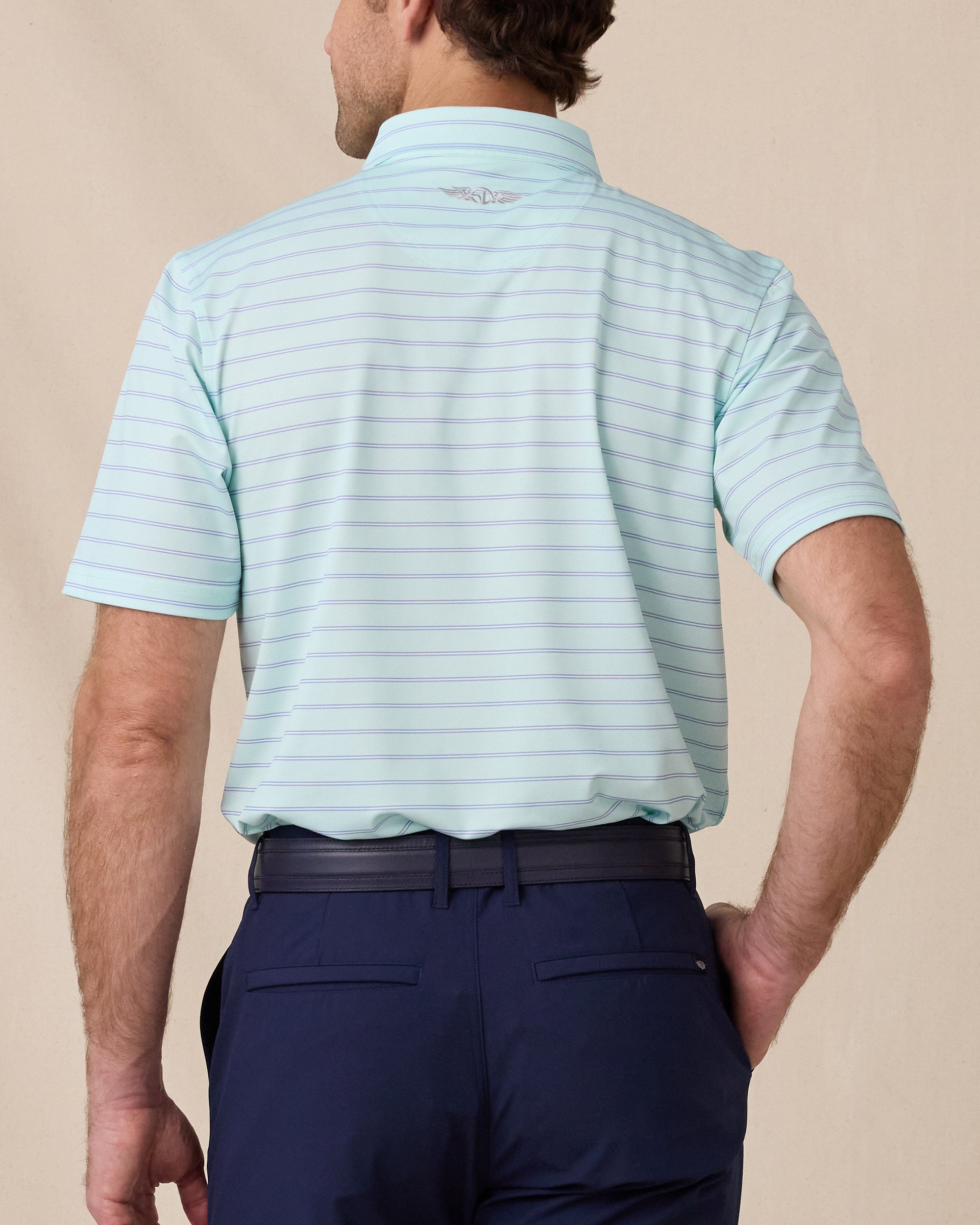 Back view of a man wearing the mint striped Quintero Polo with navy pants.