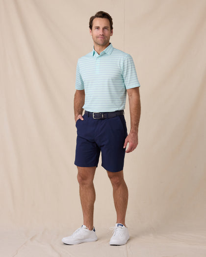 Man wearing the Quintero Stripe Polo in Mint Tea with navy shorts and white golf shoes.