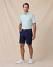 Man wearing the Quintero Stripe Polo in Mint Tea with navy shorts and white golf shoes.