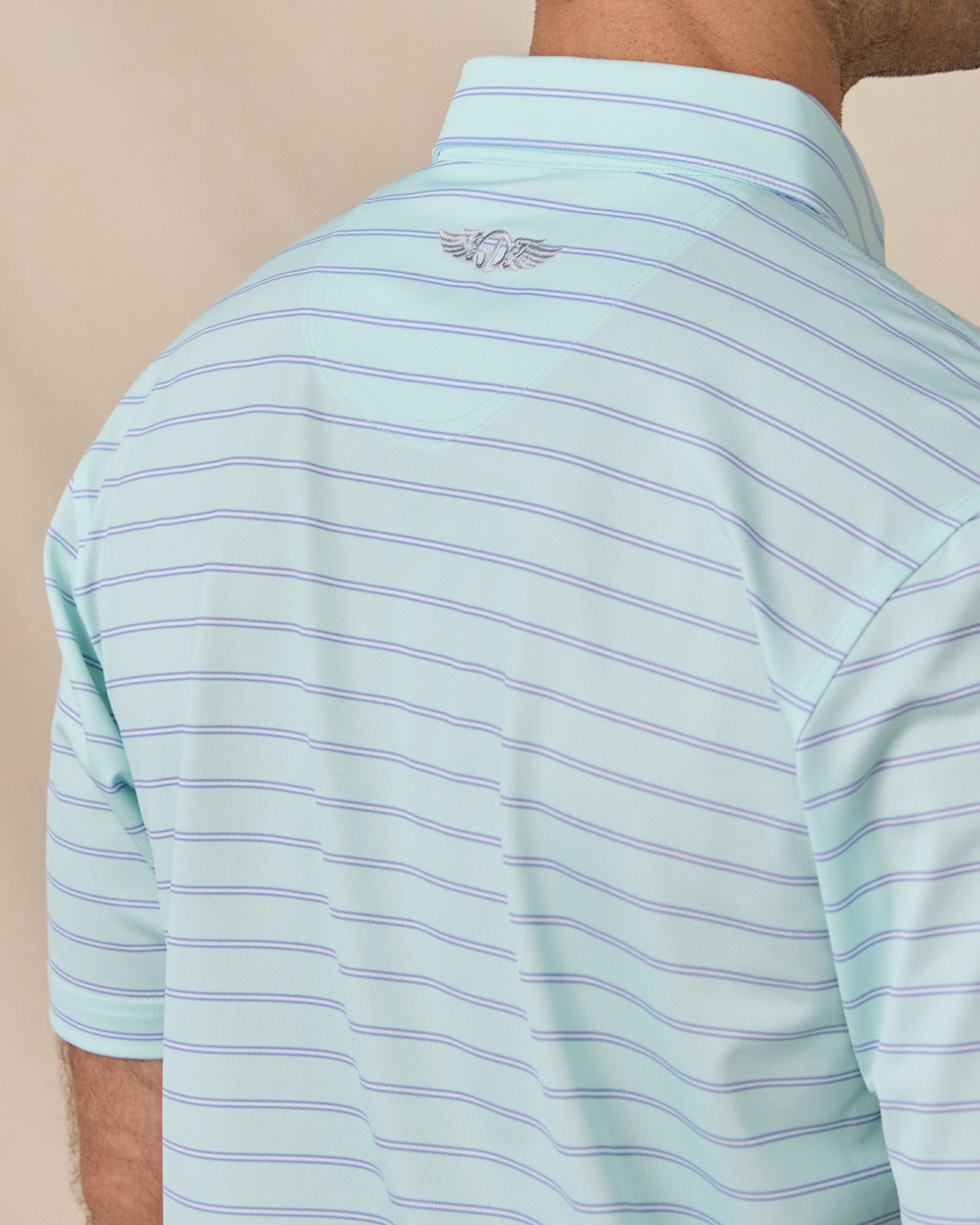 Close-up of the polo’s back collar, horizontal stripes and embroidered Straight Down logo.