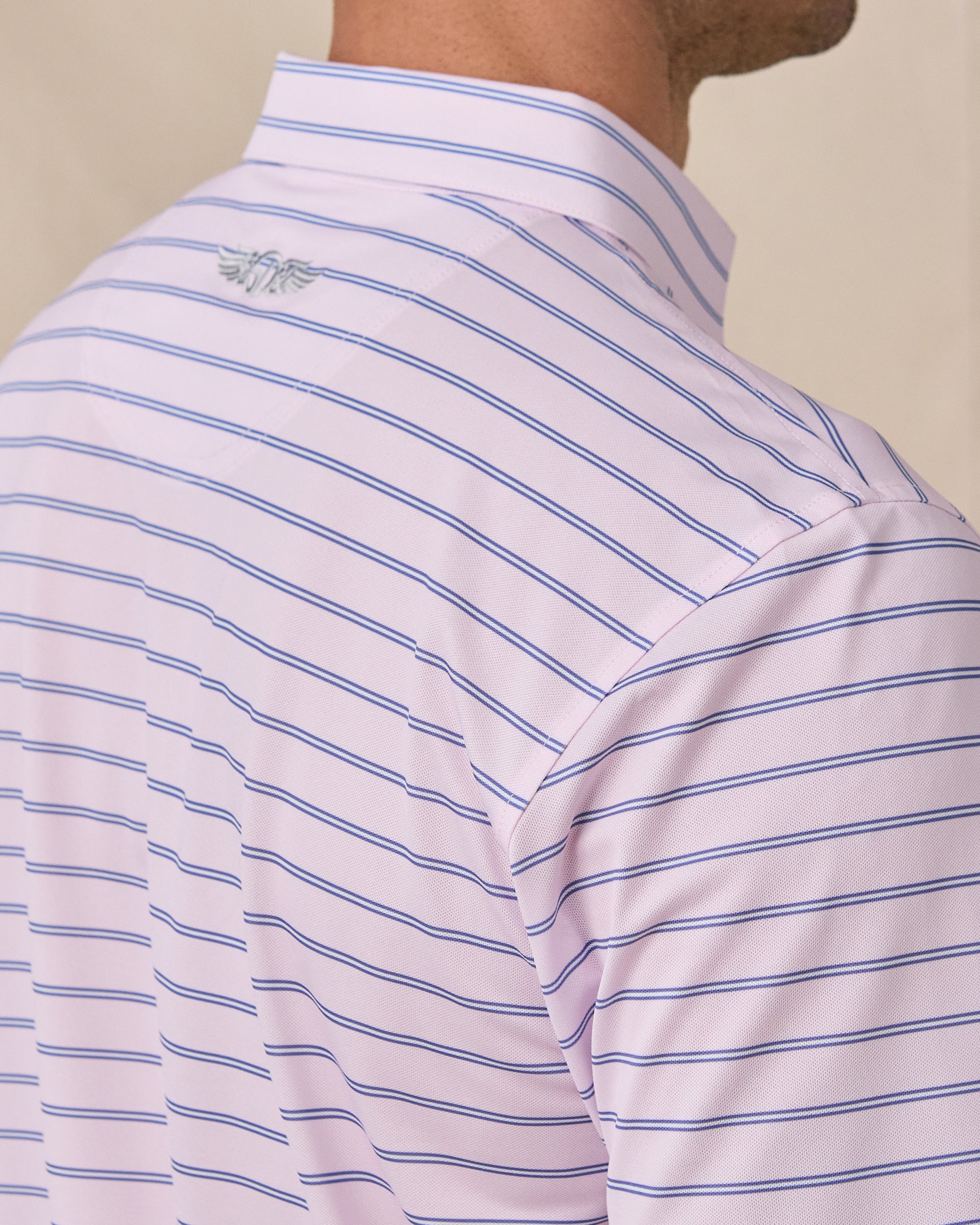 Sleeve and shoulder detail of the Quintero Stripe Polo in Lilac stripe pattern and signature Straight Down logo embroidery