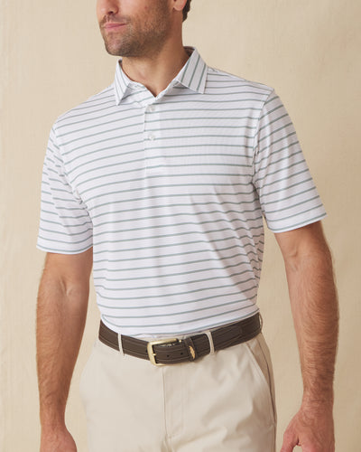 Men's Quintero Stripe Polo in Sage, front model view featuring a white short sleeve polo with horizontal green and sage pencil stripes paired with khaki pants and a brown belt