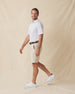Men's Quintero Stripe Polo in Sage, full length model view featuring a white short sleeve polo with horizontal green and sage pencil stripes paired with khaki shorts and white shoes