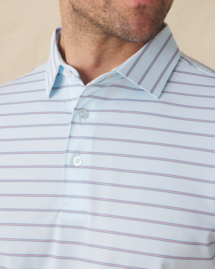 Men's Quintero Stripe Polo in Sea Spray, close-up model view featuring the collar and button placket detail of a light blue short sleeve polo with horizontal pink and steel blue pencil stripes