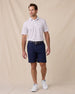 Model wearing the Quintero Stripe Polo in Tidal paired with navy golf shorts, a navy belt, and white golf shoes