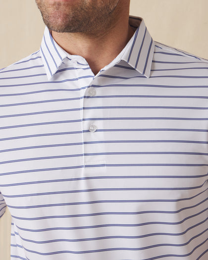 Men's Quintero Stripe Polo in Violet, close-up model view featuring the collar and button placket detail of a white short sleeve polo with horizontal blue and navy pencil stripes
