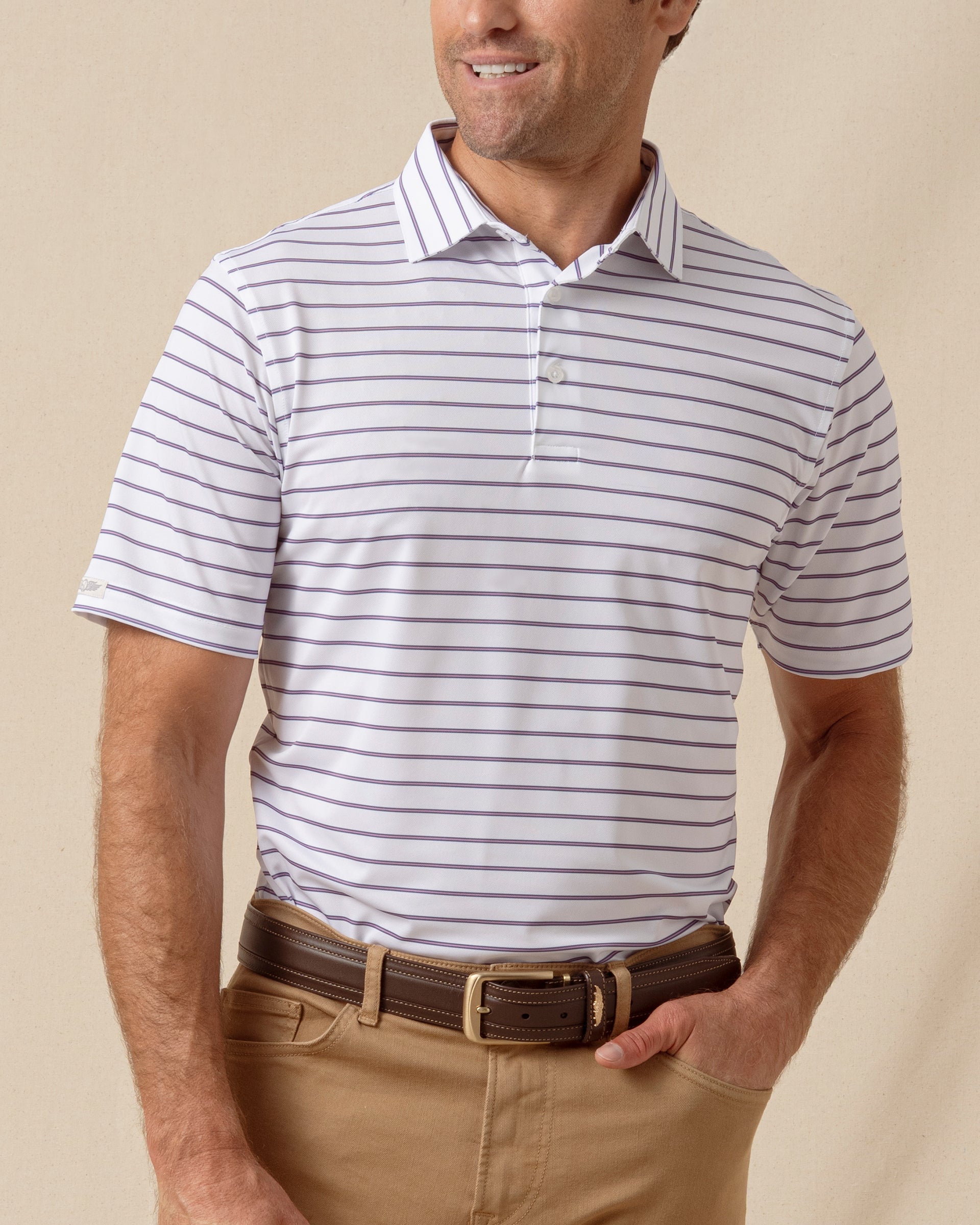 Men’s white polo with thin purple stripe pattern, styled with tan pants and brown belt