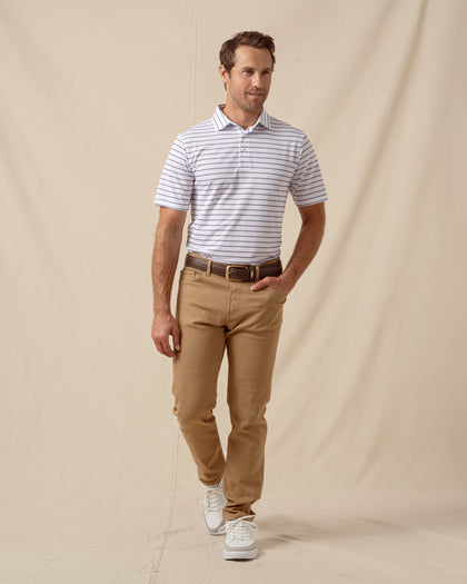 Men’s striped polo shirt paired with tan pants and white sneakers in a casual look