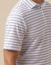 Close-up of short sleeve on striped polo with embroidered logo tab