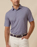 Men’s striped performance polo in indigo and lilac, paired with light khaki pants and a leather belt