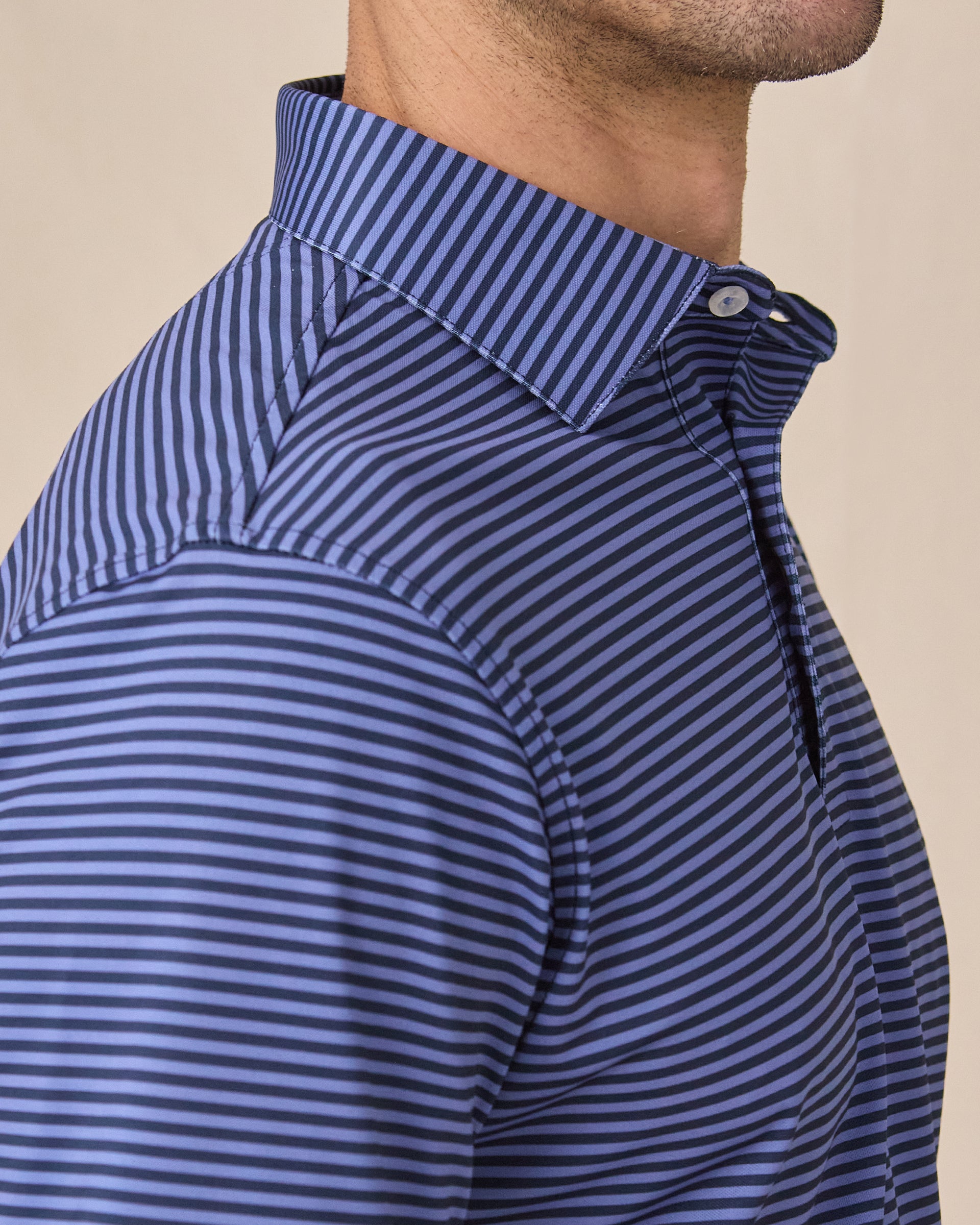 Close-up of tidal blue striped polo sleeve with embroidered logo detail