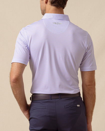 Back view of men’s striped violet polo with collar logo detail, tucked into navy shorts