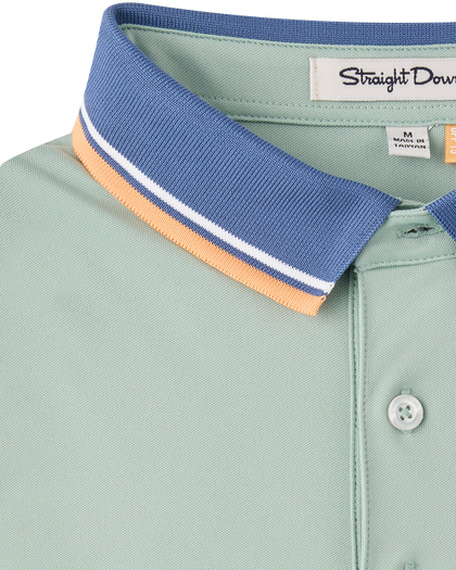 Close-up of the Chorro Polo in Herb highlighting the textured blue collar with white and orange stripe accents.