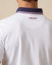Back collar detail of white polo with embroidered logo and contrast striped trim