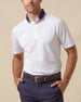 Men’s white short sleeve polo featuring a contrast striped collar and button placket