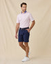 Model wearing the Chorro Polo in Lilac paired with navy golf shorts, a navy belt, and white golf shoes
