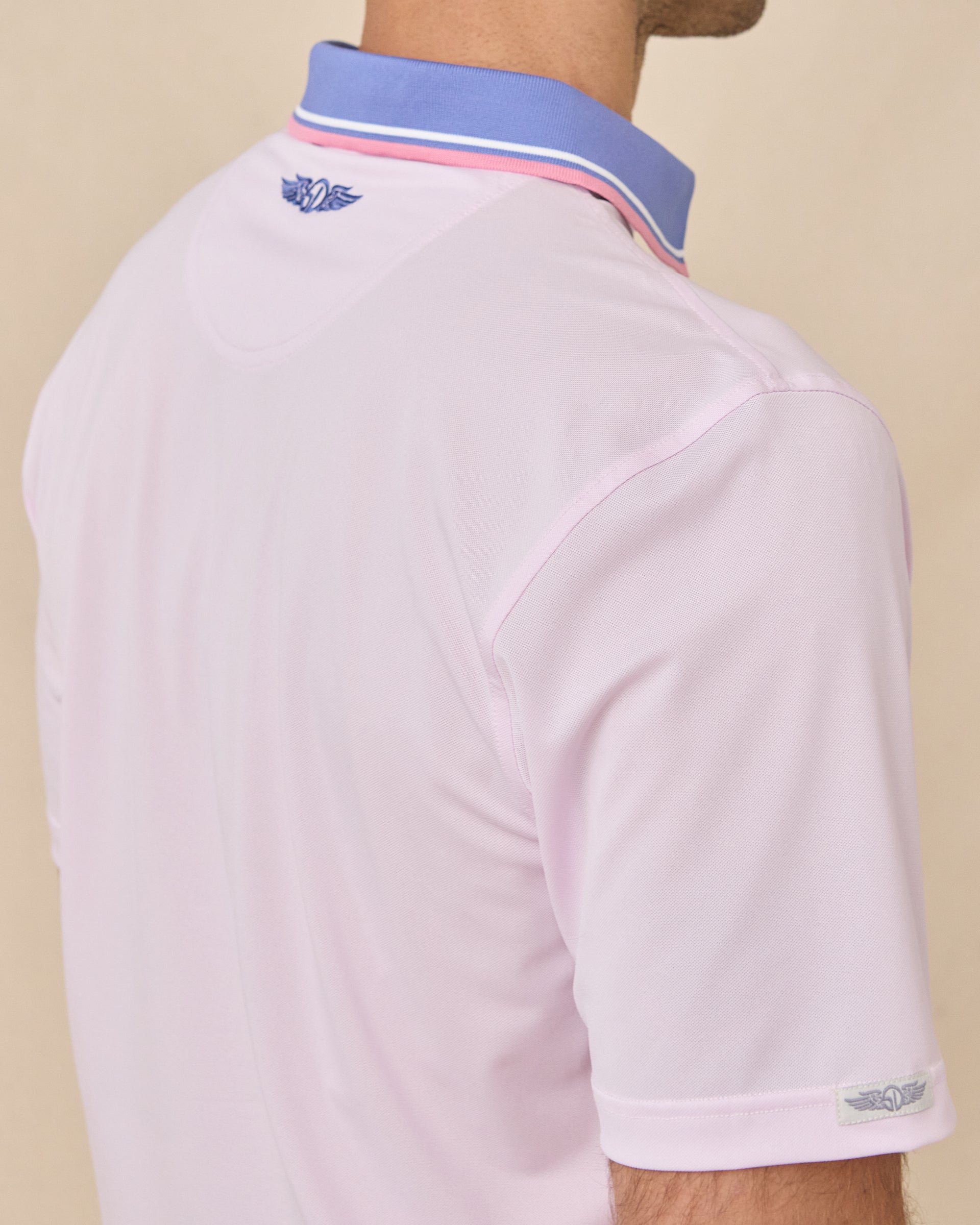 Sleeve and collar detail of the Chorro Polo in Lilac showing the contrast blue collar with pink and white tipping and signature logo embroidery