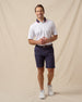 Chorro Polo in White with New Indigo collar and red trim, full outfit model view paired with dark shorts