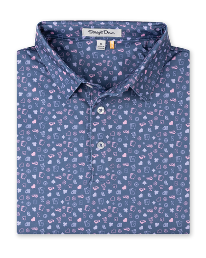 Men's Hold Em Polo in Moonlight, folded flat lay front view featuring an allover casino-themed print with playing cards, card suits, poker chips, dice, and cocktail glasses in pink and lavender on a slate blue base