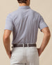 Back view of men’s navy and white striped performance polo tucked into light gray shorts