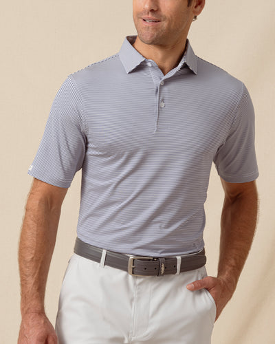 Men’s navy and white striped performance polo paired with light gray shorts and a belt