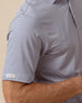 Close-up of men’s striped performance polo sleeve with subtle logo detail