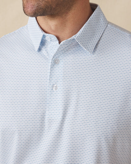 Men's Wilshire Polo in Gemstone, close-up front view on model highlighting the all-over blue geometric micro print on a white base