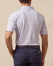 Back view of men’s haze polo with two-tone geometric print tucked into navy shorts