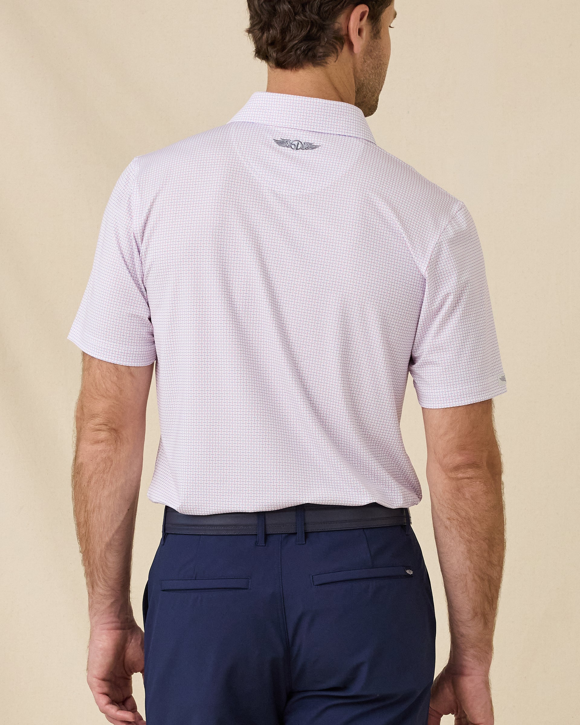 Back view of the Wilshire Polo in Punch featuring the allover geometric print and embroidered Straight Down logo below the collar