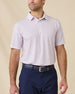 Model wearing the Wilshire Polo in Punch, a performance golf polo with a subtle geometric print